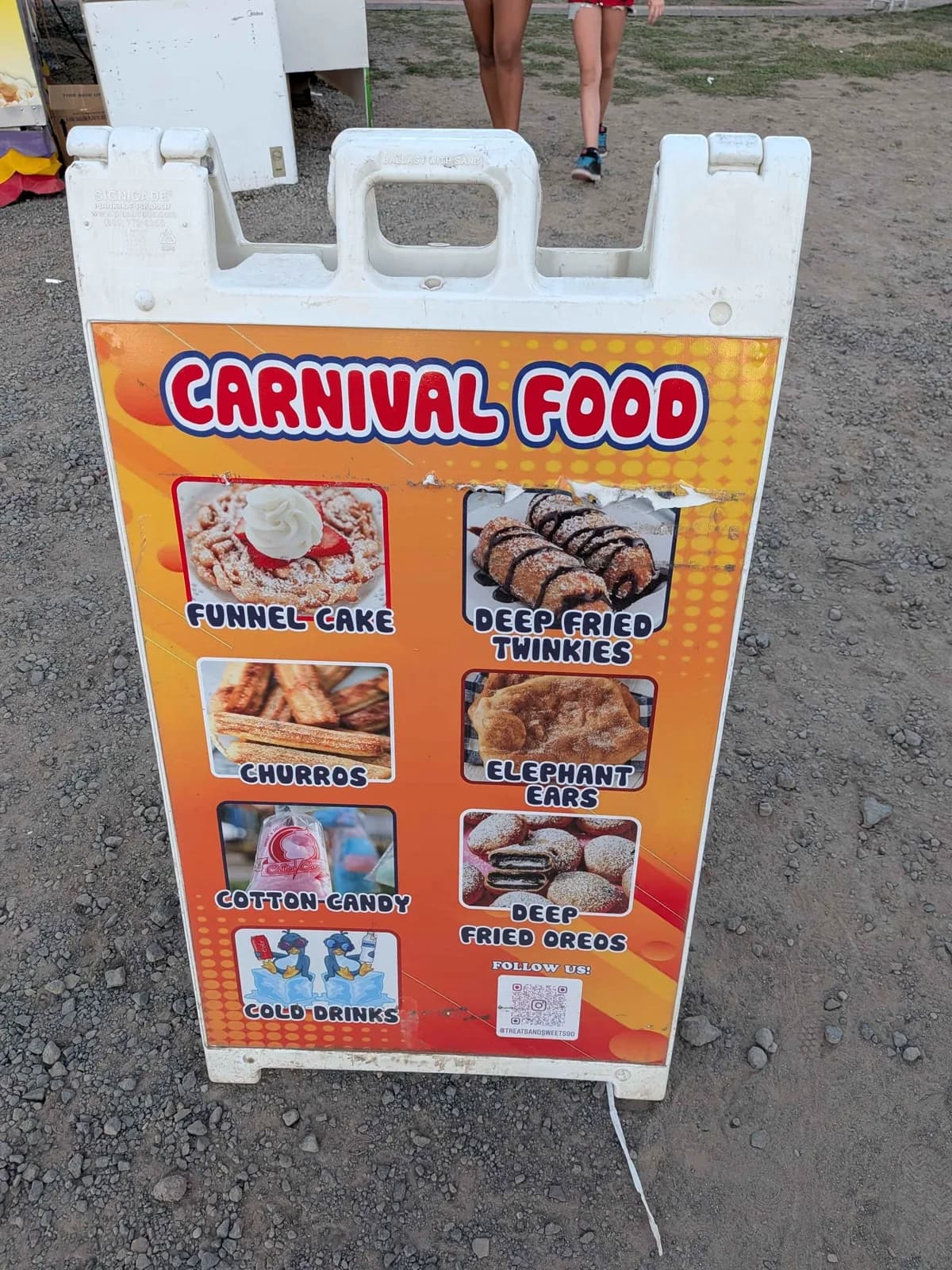Carnival food sign showing funnel cake, churros, cotton candy, cold drinks, elephant ears, and deep fried Oreos