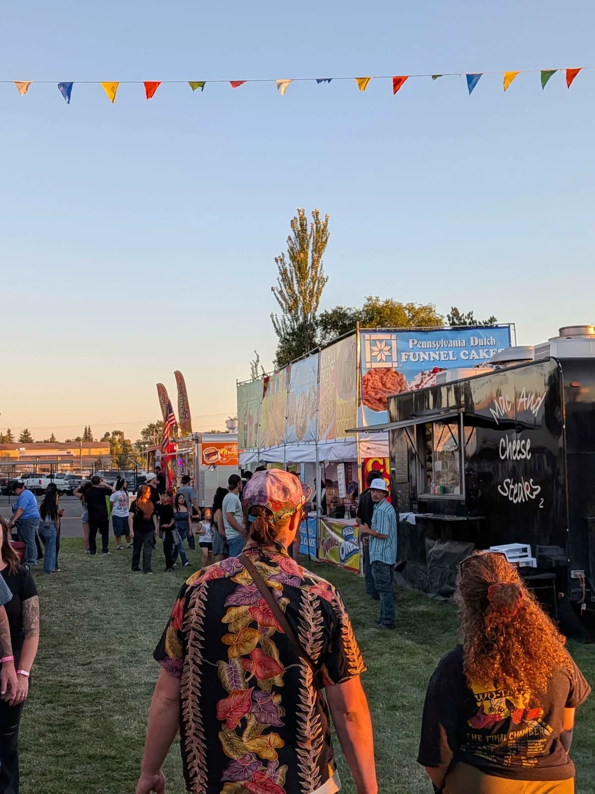 Klamath County Fair food court at golden hour with pennant flags and vendor trailers